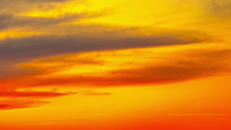 Vibrant-fiery-sunset-or-sunrise-sky-with-clouds,-time-lapse