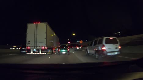 Series-number-ten-hyperlapse-showing-car-driving-away-from-downtown-Dallas-Texas-at-night-with-city-lights,-stop-and-go-traffic,-and-general-interstate-driving