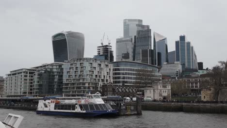 Der-Anblick-Eines-Am-Tower-Millennium-Pier-In-London-Festgemachten-Flussboots-Und-Einer-Modernen-Architektur-Am-Flussufer-Erinnert-An-Reisen,-Entdeckungen-Und-Bewunderung-Für-Zeitgenössisches-Design