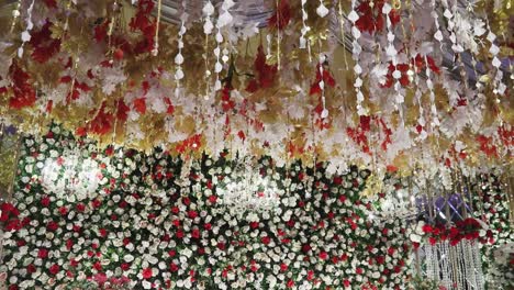 The-stage-is-adorned-with-vibrant-flowers-and-an-elegant-white-chandelier,-captured-in-a-close-up-shot-with-a-panning-view