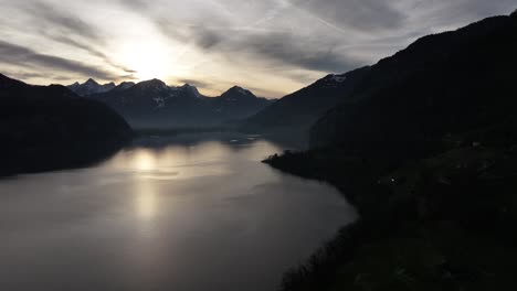 Sunset-silhouettes-Churfirsten-peaks-at-Walensee,-Switzerland---aerial