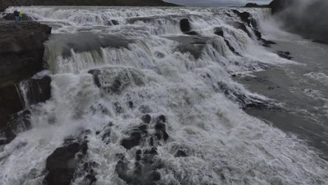 Flying-Above-Gullfoss-Waterfall-Cascades,-Glacial-Water-and-Landscape-on-Cold-Humid-Day,-Iceland