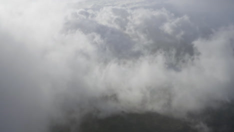 Drone-dolly-view-through-clouds-moving-over-the-landscape-of-Maui-in-Hawaii-at-daylight
