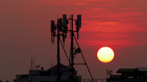 Timelapse-De-Puesta-De-Sol-En-El-Cielo-Naranja-Con-Antenas-Celulares-En-Marco