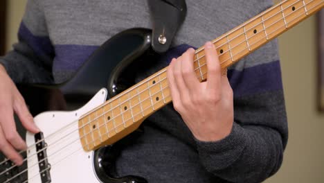 Detailed-view-of-a-man's-hands-and-fingers-on-fretboard-of-an-electric-bass