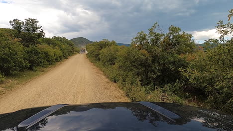 Logging-truck-passing-by-while-driving-on-dirt-road,-POV-shot