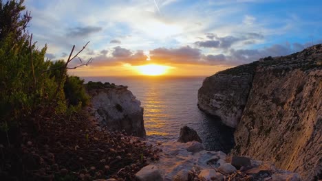 Goldener-Sonnenuntergang-Im-Zeitraffer-Aufgenommen,-Herabsteigend-über-Ruhigen-Felsigen-Klippen-Am-Meer