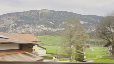 Mit-Dem-Zug-Durch-Österreich-Reisen,-Vorbei-An-Traditionellen-Dörfern-Im-Schatten-Der-Alpen