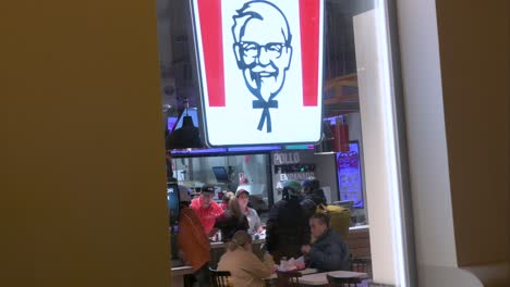 Customers-are-seen-eating-at-the-American-fast-food-chicken-restaurant,-Kentucky-Fried-Chicken-,-chain-during-nighttime