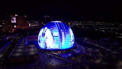 Aerial-View-of-Sphere-at-Night,-Las-Vegas-USA-With-Paramount-Plus-Advert,-Shiny-Futuristic-Building-and-Venue