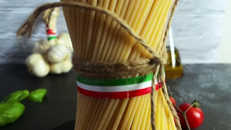 Closeup-shot-italian-spaghetti-pasta-Italy-flag-kitchen-tomato-garlic-basil-rope-tied-view,-kitchen-with-cooking-ingredients-close-up-spinning