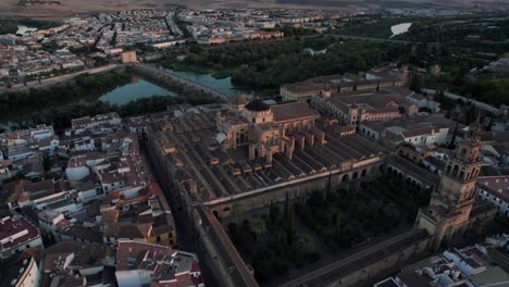 Vista-Aérea-Hacia-Atrás-De-La-Mezquita-catedral-Y-El-Río-Guadalquivir-En-Córdoba,-España