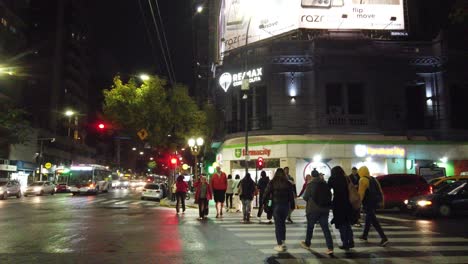 Menschen-Gehen-In-Buenos-Aires,-Einer-Pulsierenden-Metropole-In-Lateinamerika,-Spazieren.-Der-Verkehr-Verläuft-An-Einer-Asphaltierten-Fläche-Mit-Werbeschildern-Und-Geschäften-Vorbei.