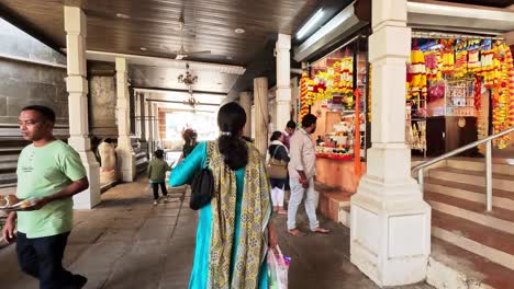 Frau-In-Farbenfroher-Indischer-Kleidung-Geht-Bewundernd-Durch-Den-Laden-Auf-Dem-Tempelgelände