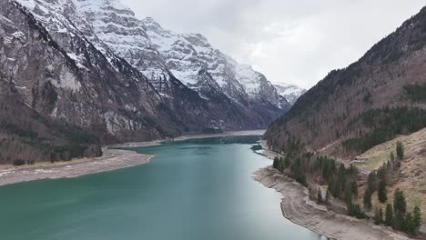 Las-Aguas-Alpinas-De-Klöntalersee-Reflejan-El-Macizo-De-Glärnisch,-Vista-Aérea-De-Los-Alpes-Suizos