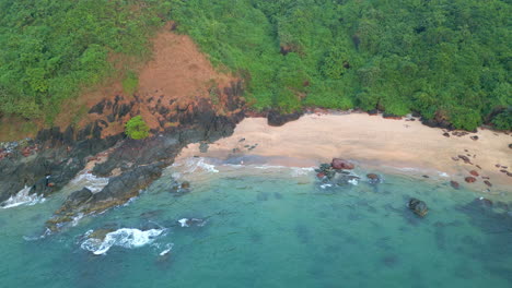 Aerial-view-of-waves-crashing-on-rock-Cola-Beach-Goa-India-4K