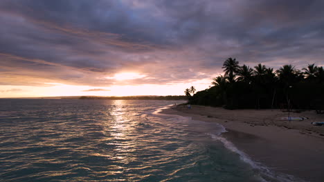 Luftdrohne-Schoss-Allein-Einen-Sandstrand-Mit-Karibischem-Meer-Während-Eines-Atemberaubenden-Goldenen-Sonnenuntergangs-Hinter-Einer-Wolkenlandschaft