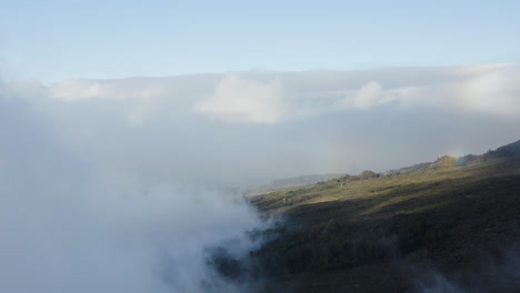 Luftaufnahme-Von-Wolken-über-Den-Berghängen-Mit-Einem-Leichten-Regenbogen-Auf-Dem-Vulkan-Haleakala