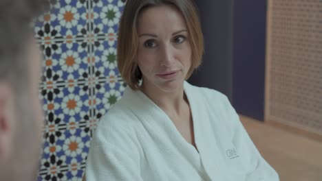 Slow-motion-shot-of-a-woman-in-a-spa-robe-chatting-whilst-waiting-on-a-treatment