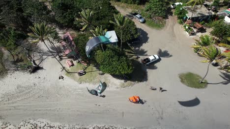 Aerial-footage-of-kitesurfers-launching-from-sandy-beach-in-Saint-Lucia,-Caribbean