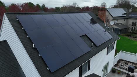 Solar-panel-Units-on-roof-of-white-house-in-american-suburb-during-cloudy-rain-day