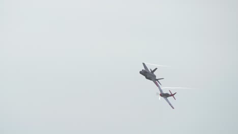 Vuelo-En-Formación-De-Dos-Barcos-Con-Un-Avión-De-Combate-F35-Y-Un-Antiguo-Pájaro-De-Guerra-P51.