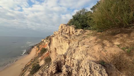 Jutting-landscape-along-Spain's-coastal-region,-where-rugged-cliffs-stand-in-stark-contrast-to-waves-crashing-against-the-shore,-portraying-the-natural-beauty-of-the-seaside-scenery