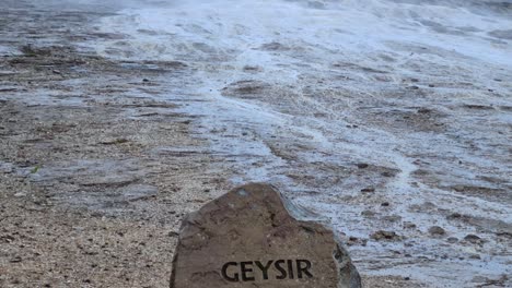 Geysir-Sign-on-Rock-and-Vapor-Above-Geyser-in-Geothermal-Area-of-Iceland