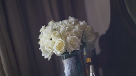 Bridal-bouquet-of-white-roses-on-dressing-table-in-hotel-room-in-the-morning