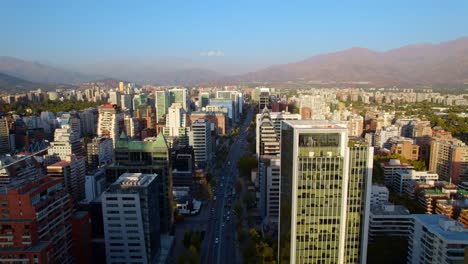 Drone-flyover-Apoquindo-Avenue-at-Las-Condes-district-Skyscrapers-Skyline-with-Andes-in-the-distance,-Santiago
