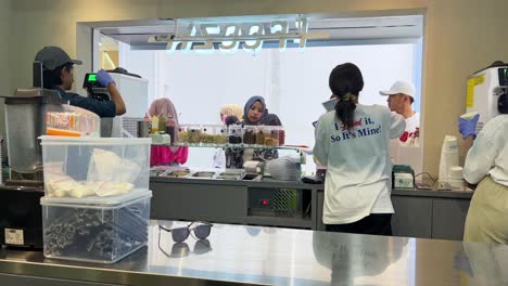 Ice-Cream-Store-Waiters-Serving-Customer,-View-From-Inside-The-Cafe