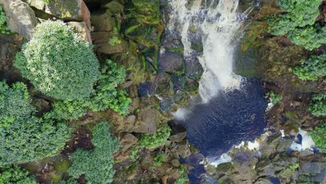 Aerial-drone-footage-of-a-tall-rocky-waterfall-in-the-Yorkshire-Dales,-Pennies