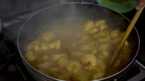 Curry-Garnelen-Gericht-Mit-Einer-Holzkelle-Umgerührt,-Beim-Kochen-Aufsteigender-Dampf