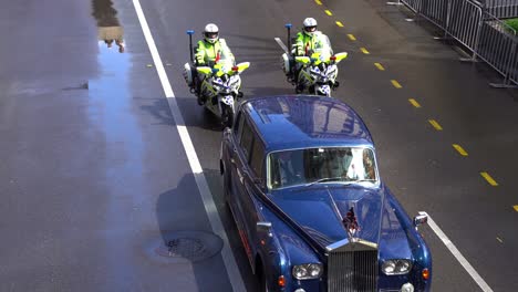 A-British-royal-car-escorted-down-Adelaide-Street-by-a-team-of-vigilant-police-officers-on-motorbikes-during-the-annual-Anzac-Day-parade-tradition,-close-up-shot