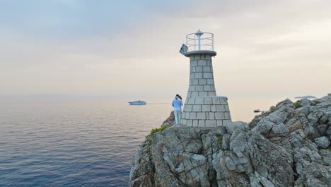 Insel-Kalamota,-Adria,-Kroatien-–-Ein-Paar-Genießt-Den-Sonnenuntergang-Neben-Dem-Leuchtturm-–-Drohnenaufnahme-Aus-Der-Umlaufbahn