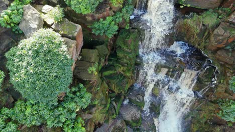 Aerial-drone-footage-of-a-tall-rocky-waterfall-in-the-Yorkshire-Dales,-Pennies