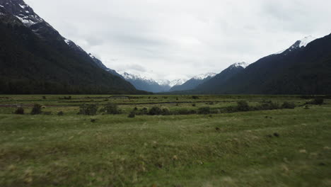 Racing-over-tussock-grasslands-and-crystal-clear-rivers-in-a-vast-valley-towards-the-snow-capped-mountains