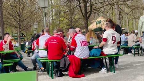 Elderly-traditional-Bavarian-Bayern-Munich-Fans-at-English-Garden-park,-talking-and-celebrating