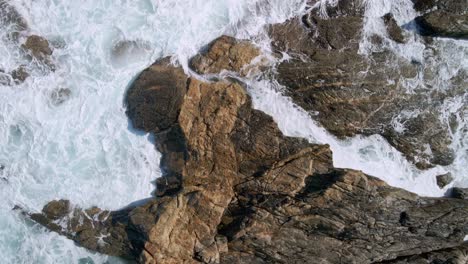 Drone-view-of-clear-rock-pool-and-choppy-waves-along-Greenly-Beach-coast,-Eyre-Peninsula,-South-Australia