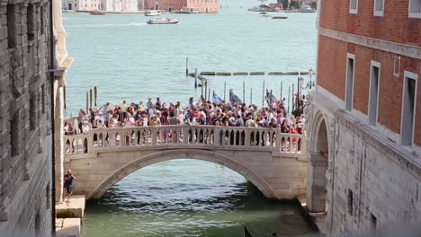 Crowded-bridge-Ponte-della-Paglia-overtourism-in-Venice,-Italy-in-summer-season