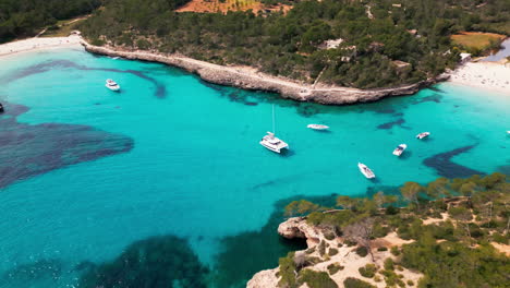 Aerial-view-of-serene-Cala-Mondrago-beach-in-Mallorca-with-crystal-waters