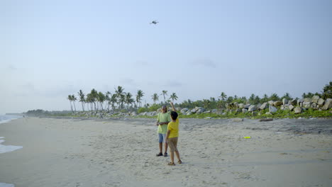 Boys-flying-a-drone-in-beach-side