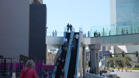 Gente-En-Escaleras-Mecánicas-En-Un-Puente-Peatonal-Durante-El-Día-En-Las-Vegas,-Nevada