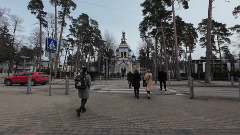 Pedestrian-walk-in-slow-motion-at-Latvia-Jurmala-city-streets-traffic-landmark-heritage-urban-park,-architecture,-Latvian-people