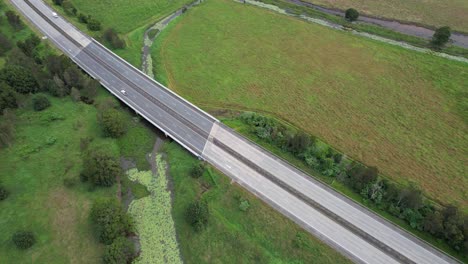 Aerial-View-Of-Pacific-Motorway-With-Vehicles-Driving-In-Daylight-Through-Fields