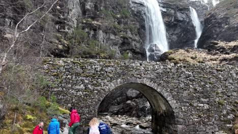 Gruppe-Von-Touristen,-Die-Den-Wasserfall-Hesjedalsfossen-Betrachten