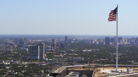 Drone-shot-that-reveals-American-flag-waving-in-wind-atop-of-skyscraper-in-Houston