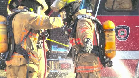 Bomberos-Limpiando-Con-Una-Manguera-Después-De-Un-Incendio-En-Un-Edificio-Abandonado-En-Montreal,-Quebec,-Canadá,-Durante-El-Día