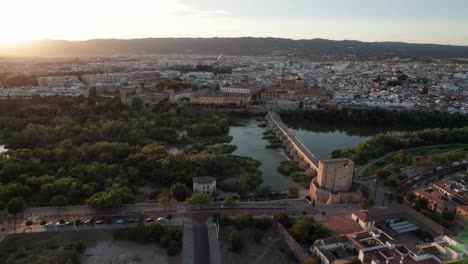 Luftaufnahme-Des-Flusses-Guadalquivir,-Einer-Alten-Stadt-Córdoba,-Spanien-Während-Der-Goldenen-Stunde