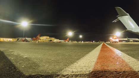 Pre-dawn-timelapse-frame-of-Malta-International-Airport,-capturing-lined-aircraft-and-glowing-terminal-lights-as-the-airport-awakens-for-daily-operations